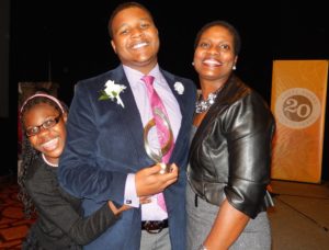 Elijah Benjamin Evans, No Use for Abuse founder, is gripped in a family hug by his mom and little sister.