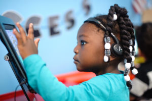Young girl playing on tablet.