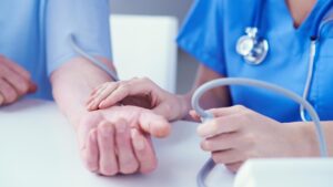 Doctor taking patient's pulse.