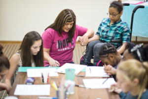 blue cross blue shield foundation volunteer praying with a group of girls